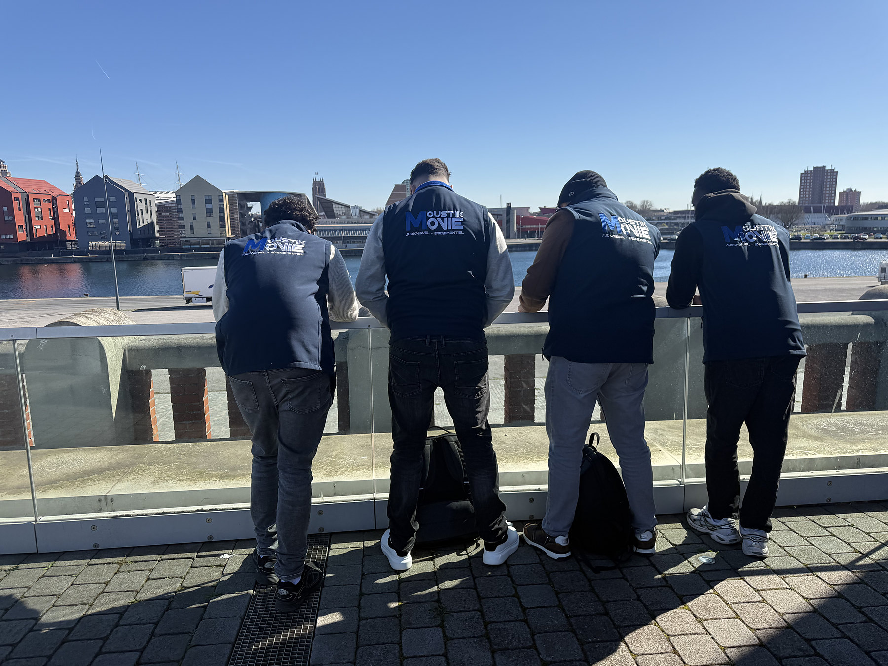 Groupe de jeunes en veste Moustik Movie regardant le port